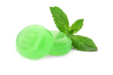 Photo of Tasty mint candies and leaves on white background