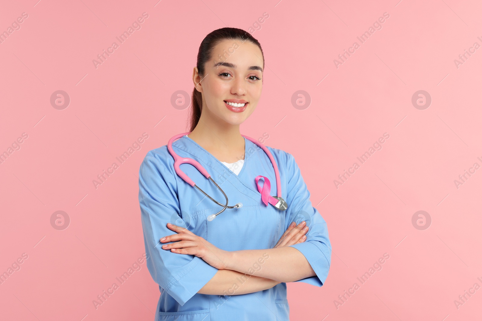 Photo of Mammologist with pink ribbon on color background. Breast cancer awareness