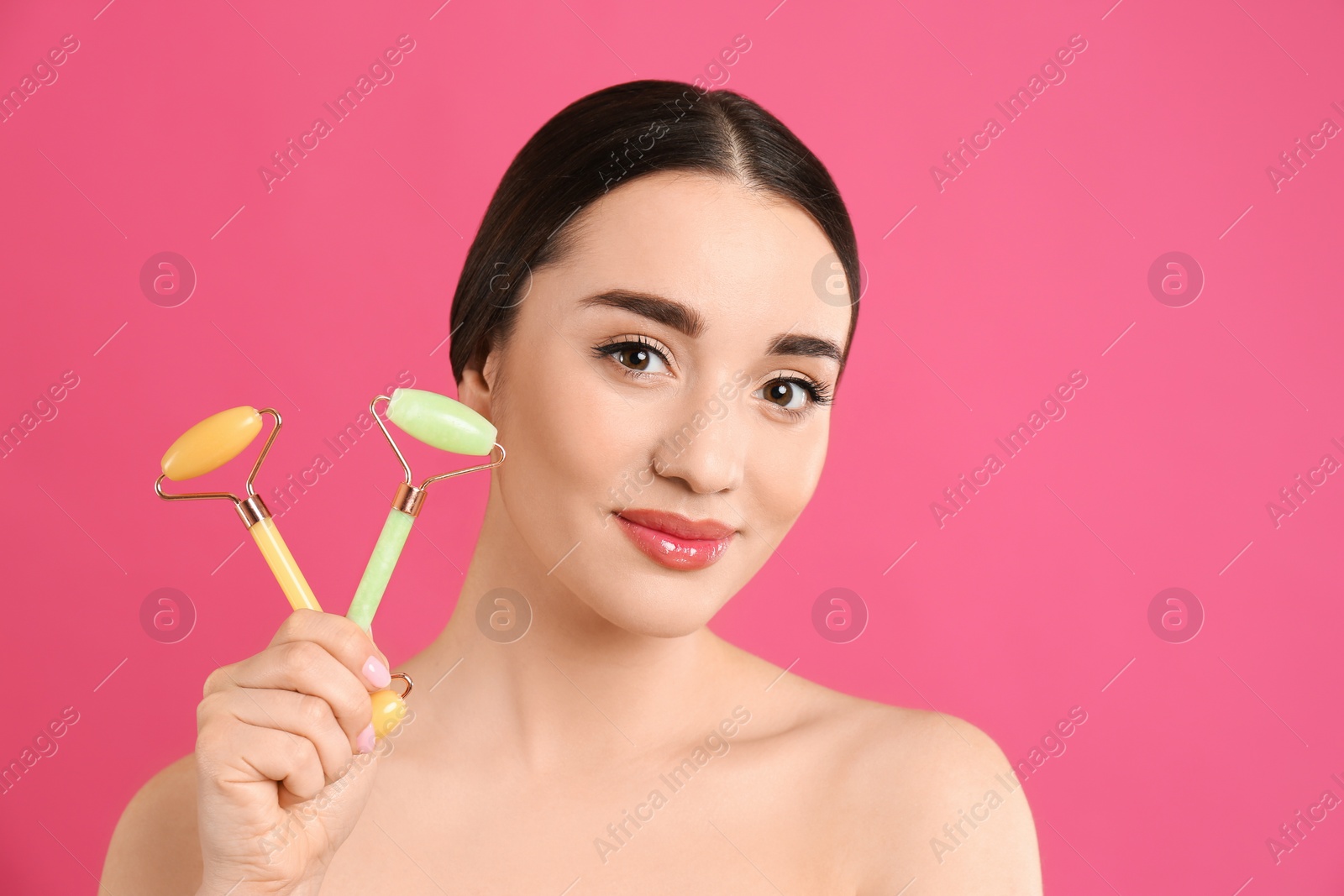 Photo of Woman with natural face rollers on pink background