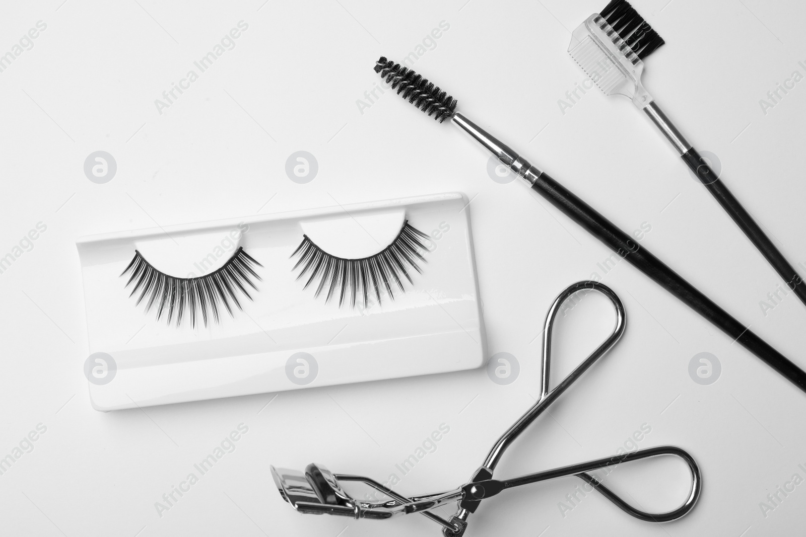 Photo of Flat lay composition of professional makeup tools and false eyelashes on white background