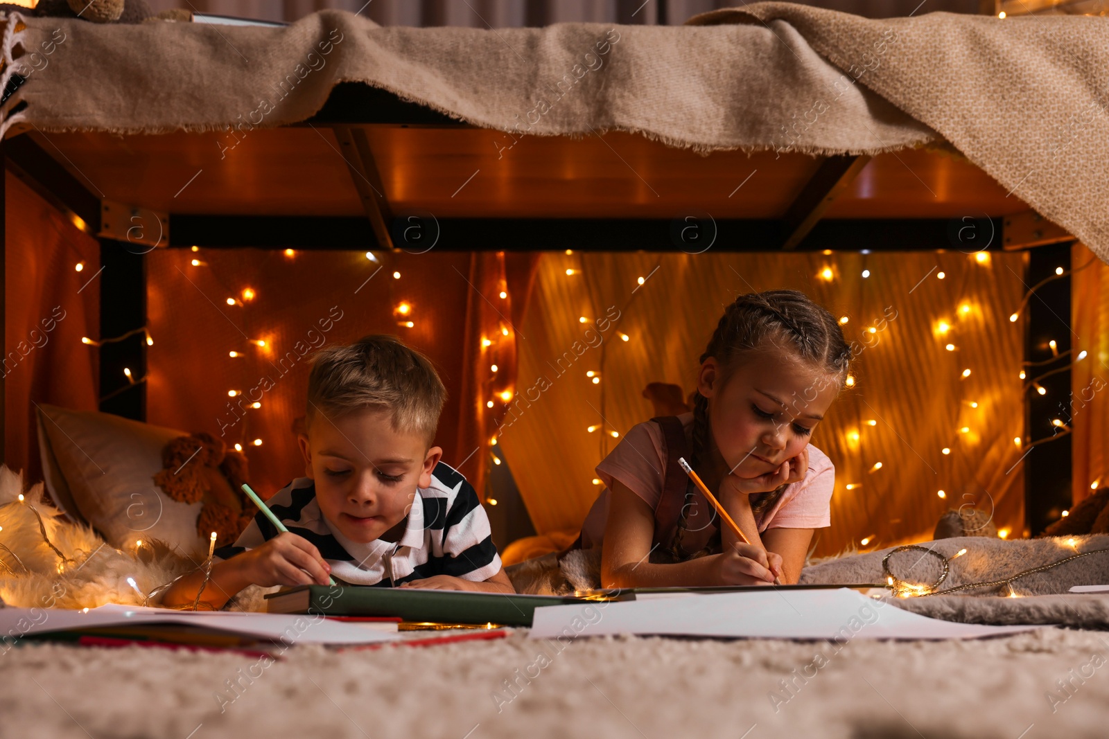 Photo of Children drawing in play tent at home