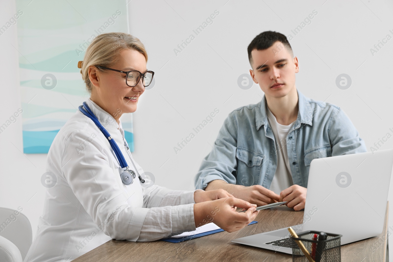 Photo of Professional doctor working with patient in clinic