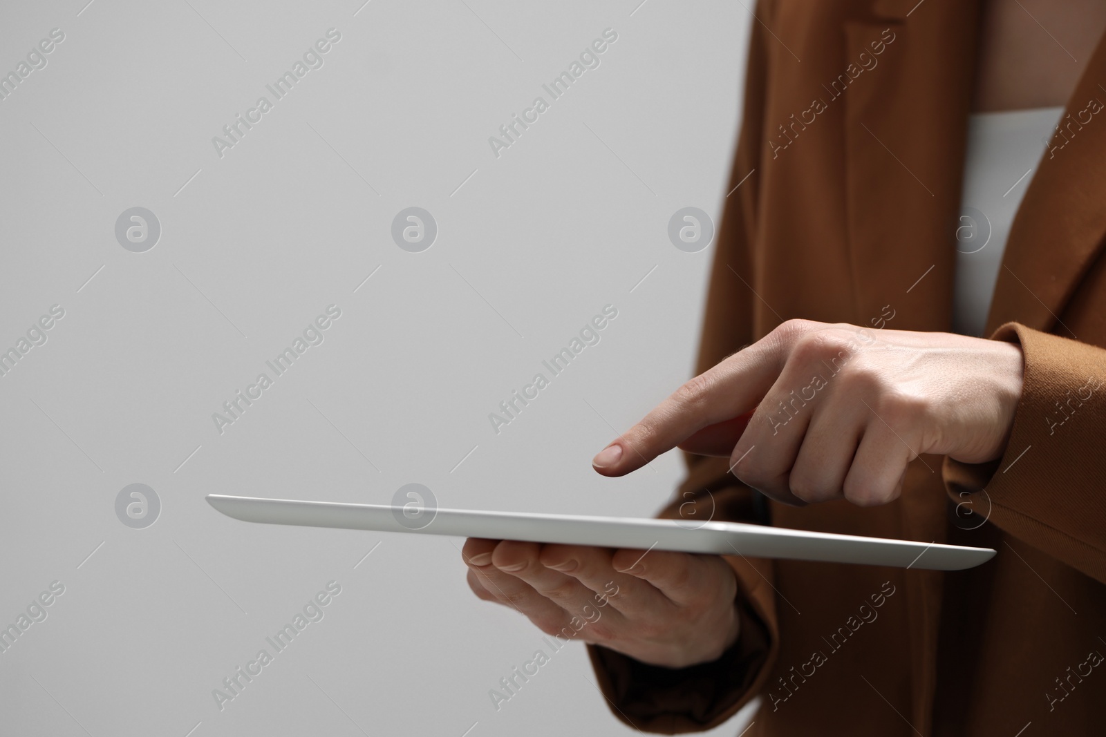 Photo of Closeup view of woman using modern tablet on grey background. Space for text