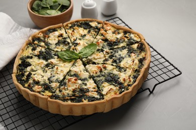 Photo of Delicious homemade spinach quiche on light gray table