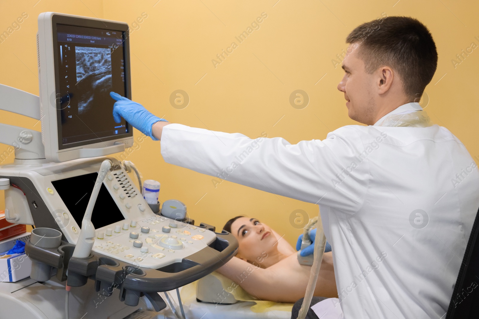 Photo of Mammologist conducting ultrasound examination of woman's breast in clinic