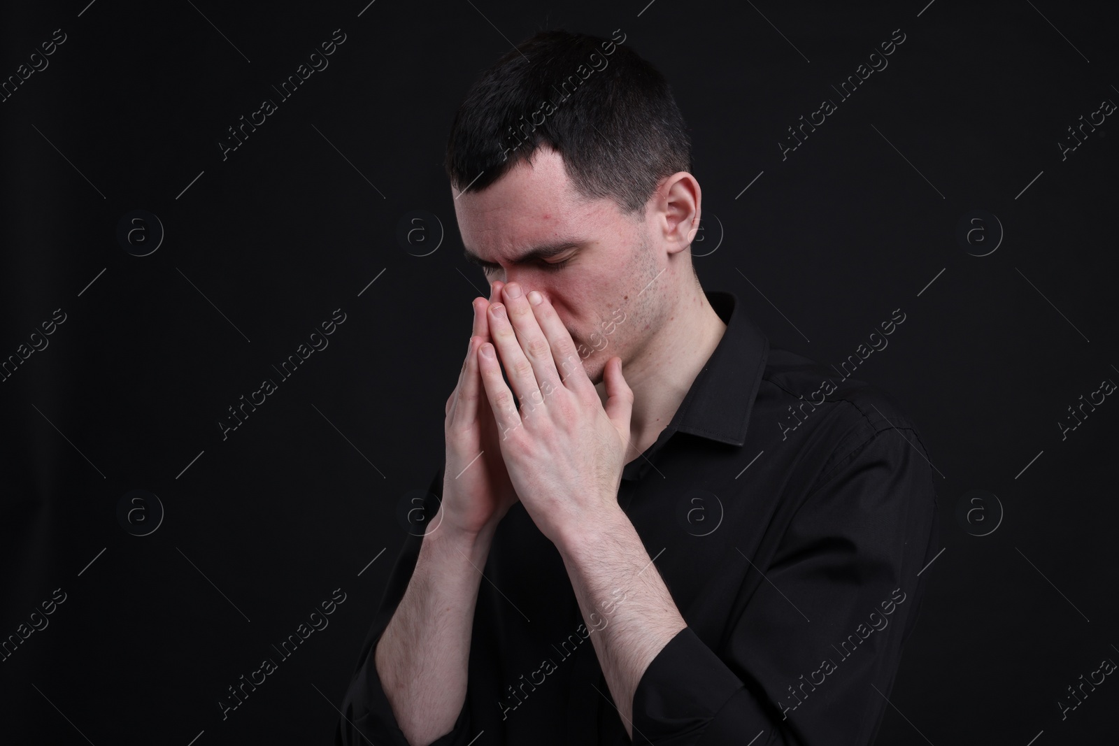 Photo of Portrait of sad man on black background, space for text