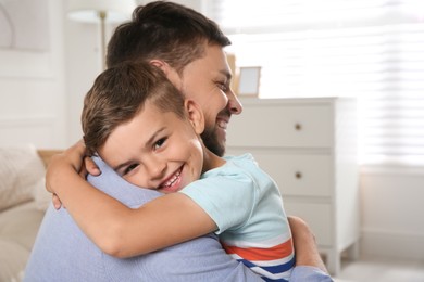 Photo of Cute little boy hugging his father at home. Adoption concept