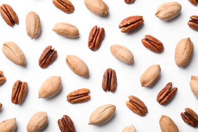 Composition with pecan nuts on white background, top view