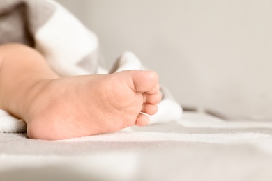 Photo of Little baby in bed, closeup on foot. Space for text