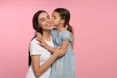 Happy woman with her cute daughter on pink background. Mother's day celebration