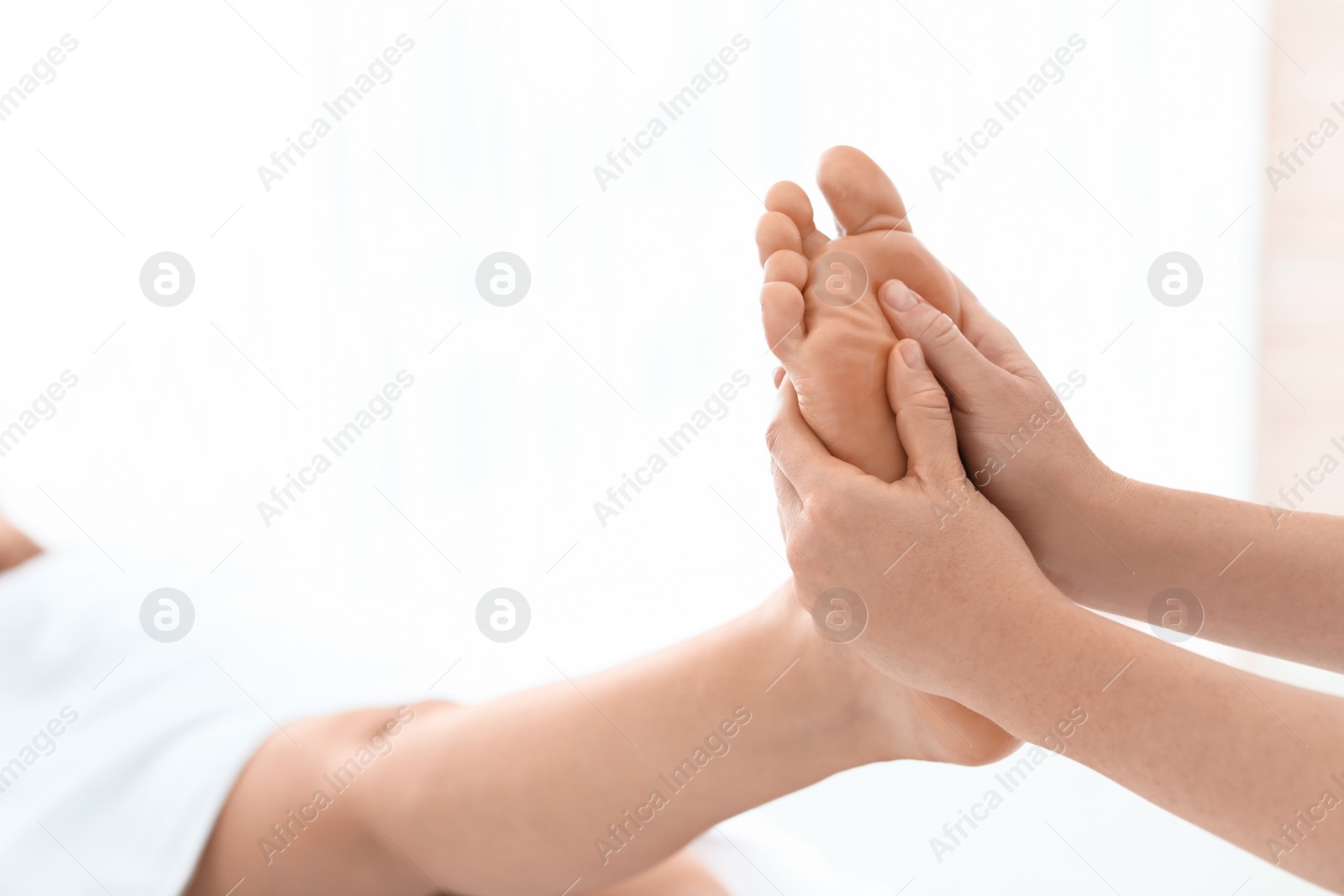 Photo of Woman receiving foot massage in wellness center, closeup