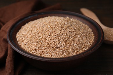 Photo of Dry wheat groats in bowl on table, closeup