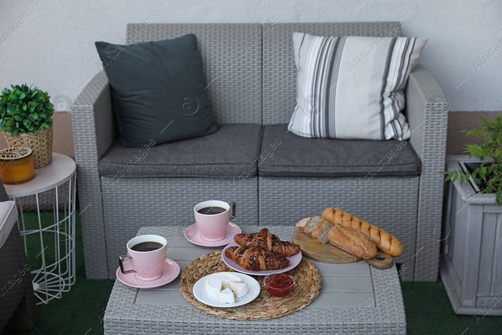 Outdoor breakfast with tea and croissants on rattan table on terrace Photo of Outdoor breakfast with tea and croissants on rattan table on terrace