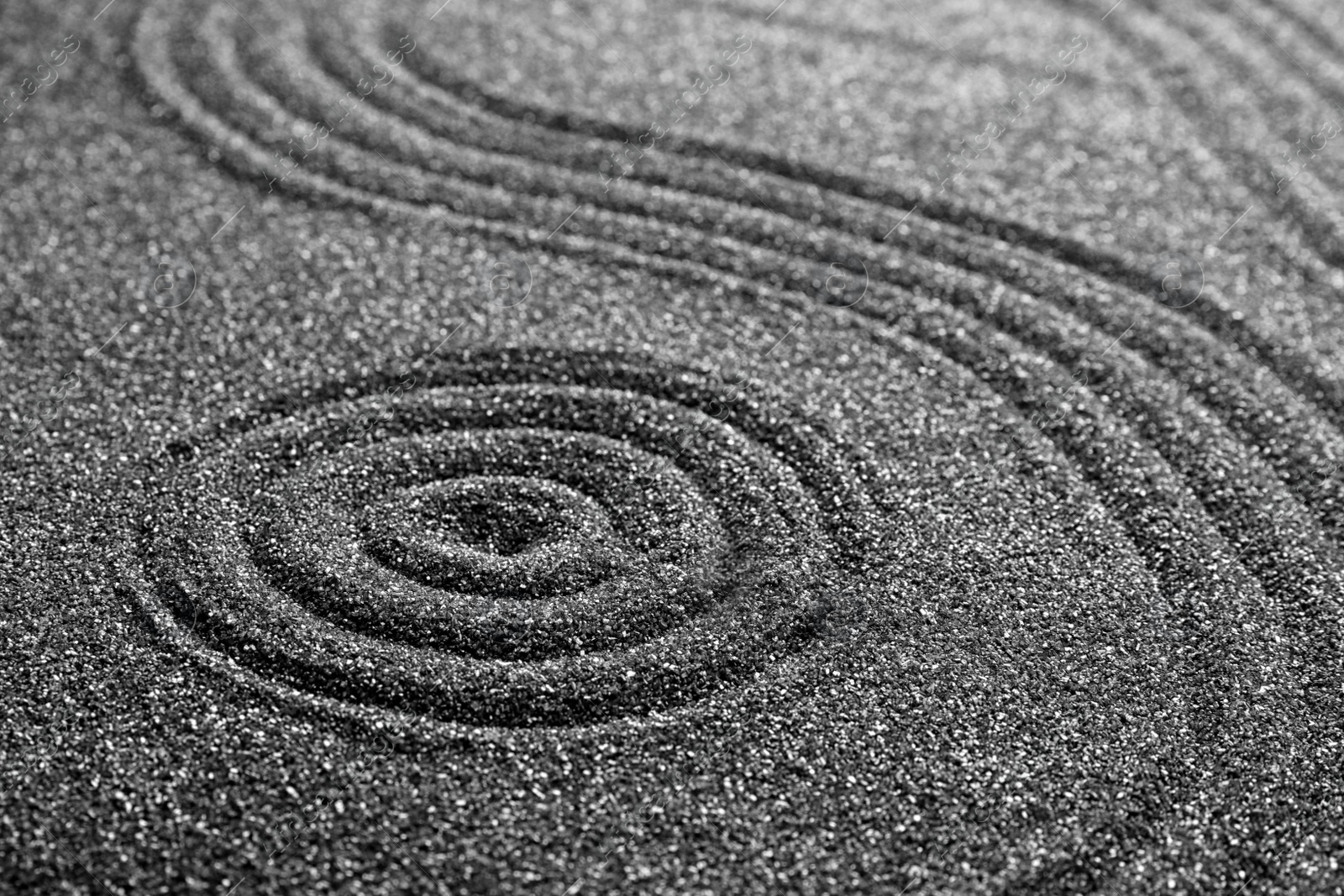 Photo of Pattern on decorative black sand, closeup. Zen and harmony