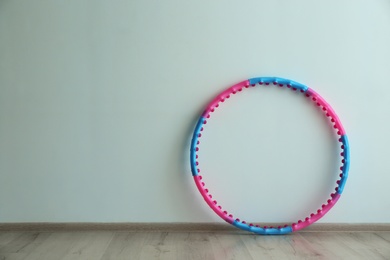 Photo of Hula hoop near light wall in gym. Space for text