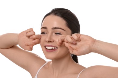 Photo of Young woman massaging her face on white background