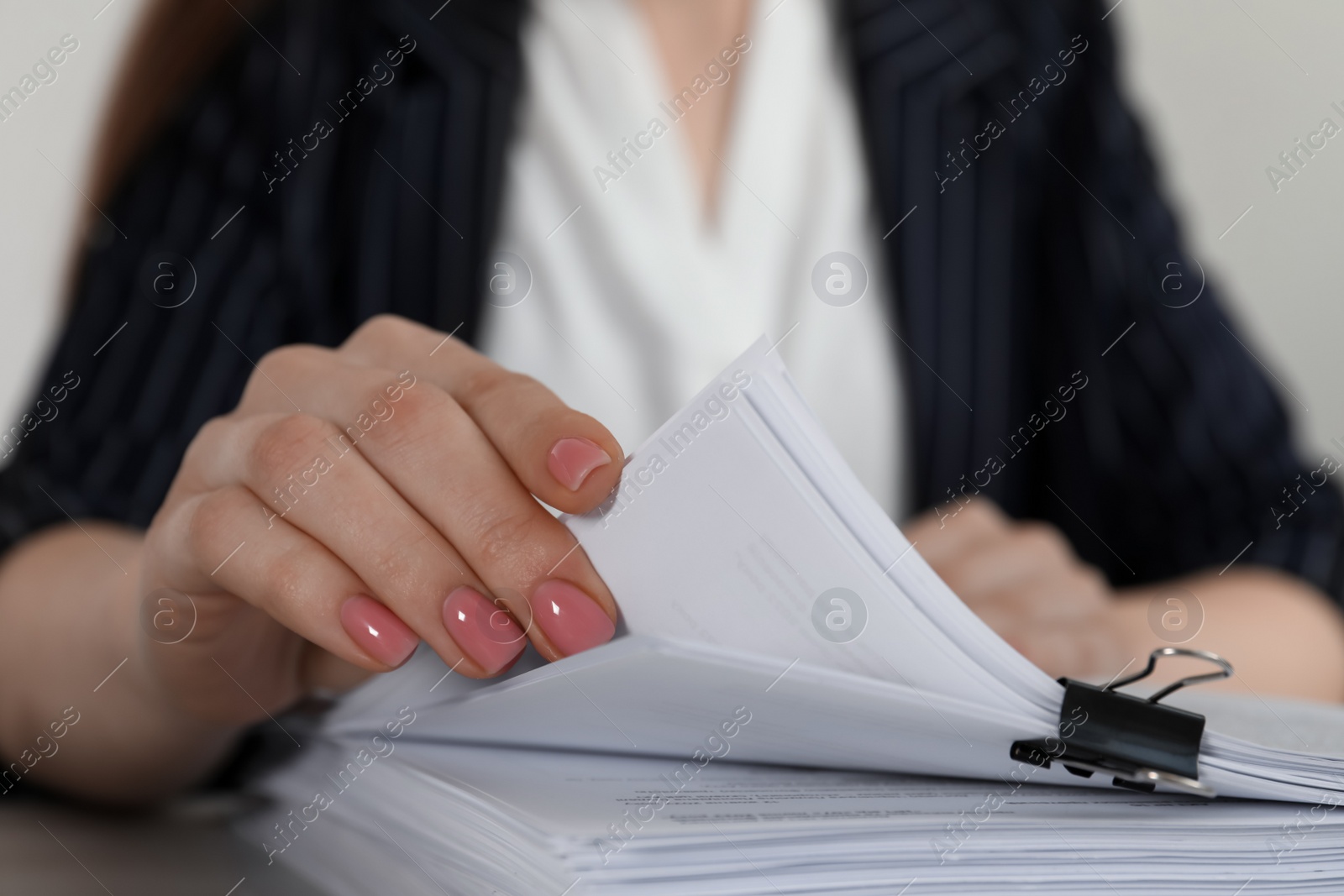 Photo of Woman reading documents at table in office, closeup
