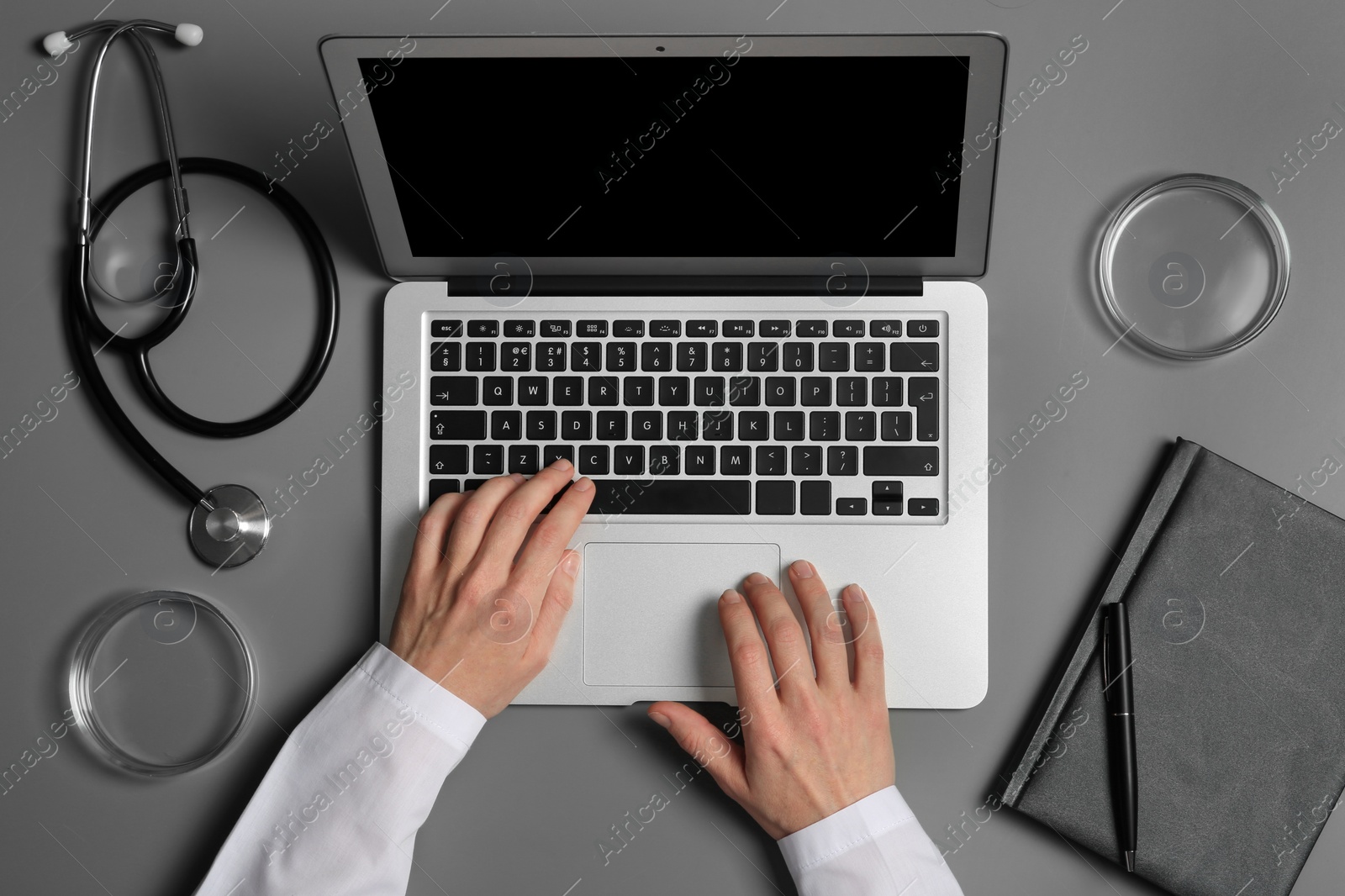 Photo of Student with modern laptop and medical stuff at table, top view