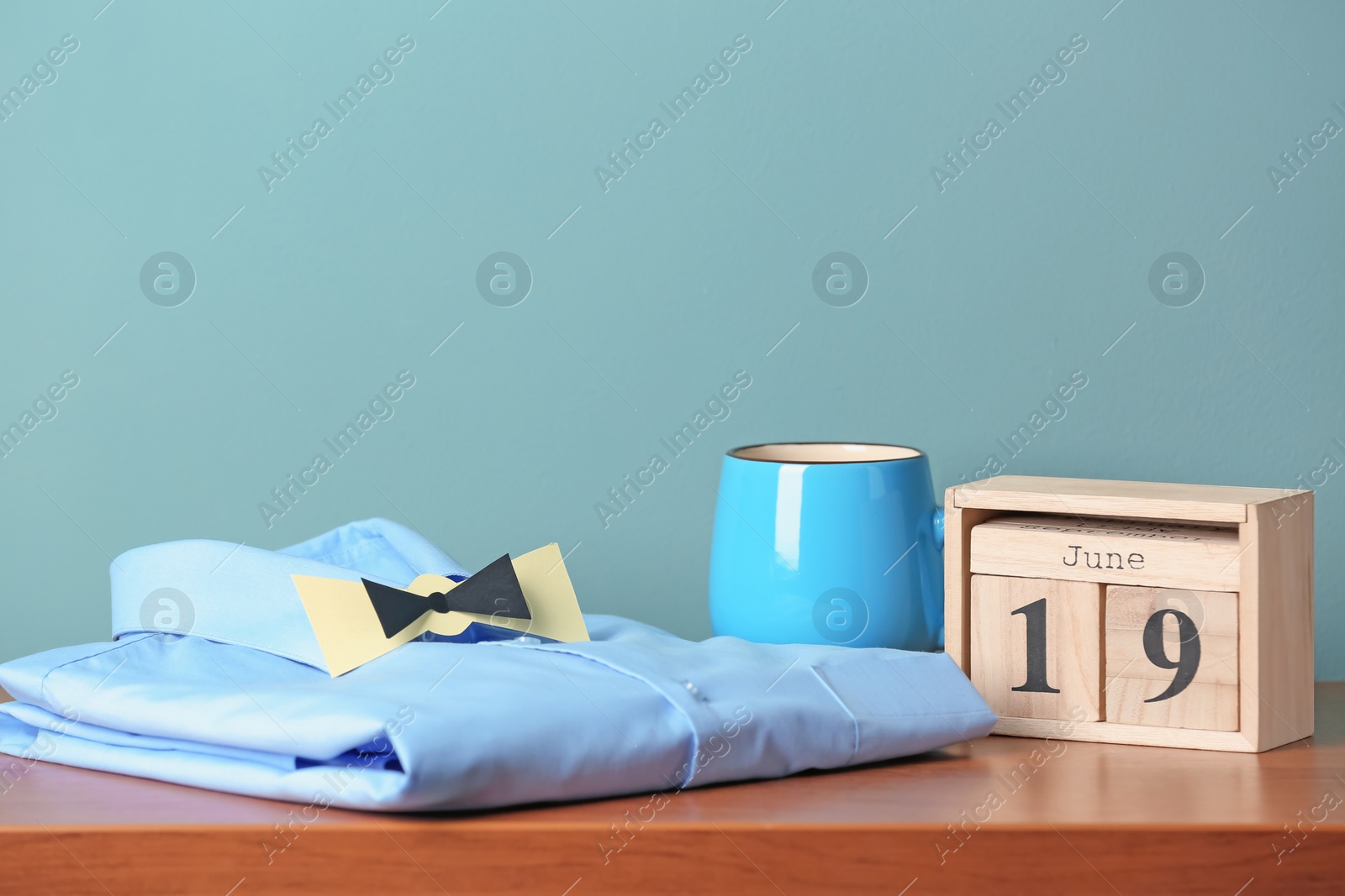 Photo of Composition with calendar and shirt on table. Father's day celebration