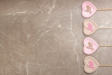 Photo of Chocolate heart shaped lollipops with word Love on light grey marble table, flat lay. Space for text