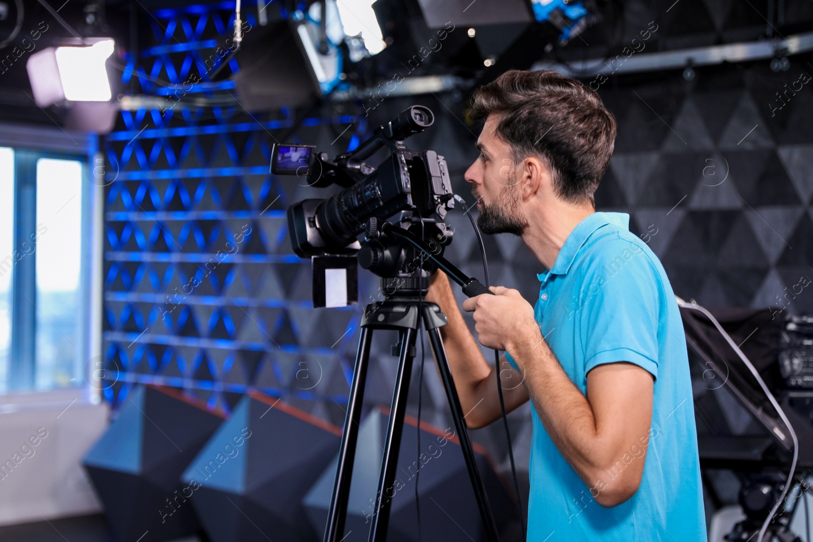 Photo of Professional video camera operator working in studio