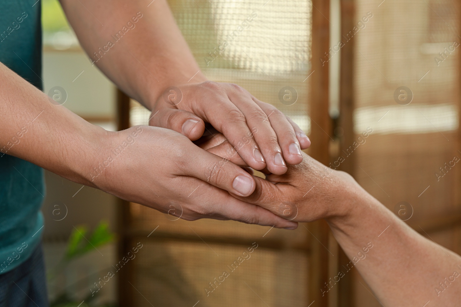 Photo of Caregiver helping elderly woman at home, closeup