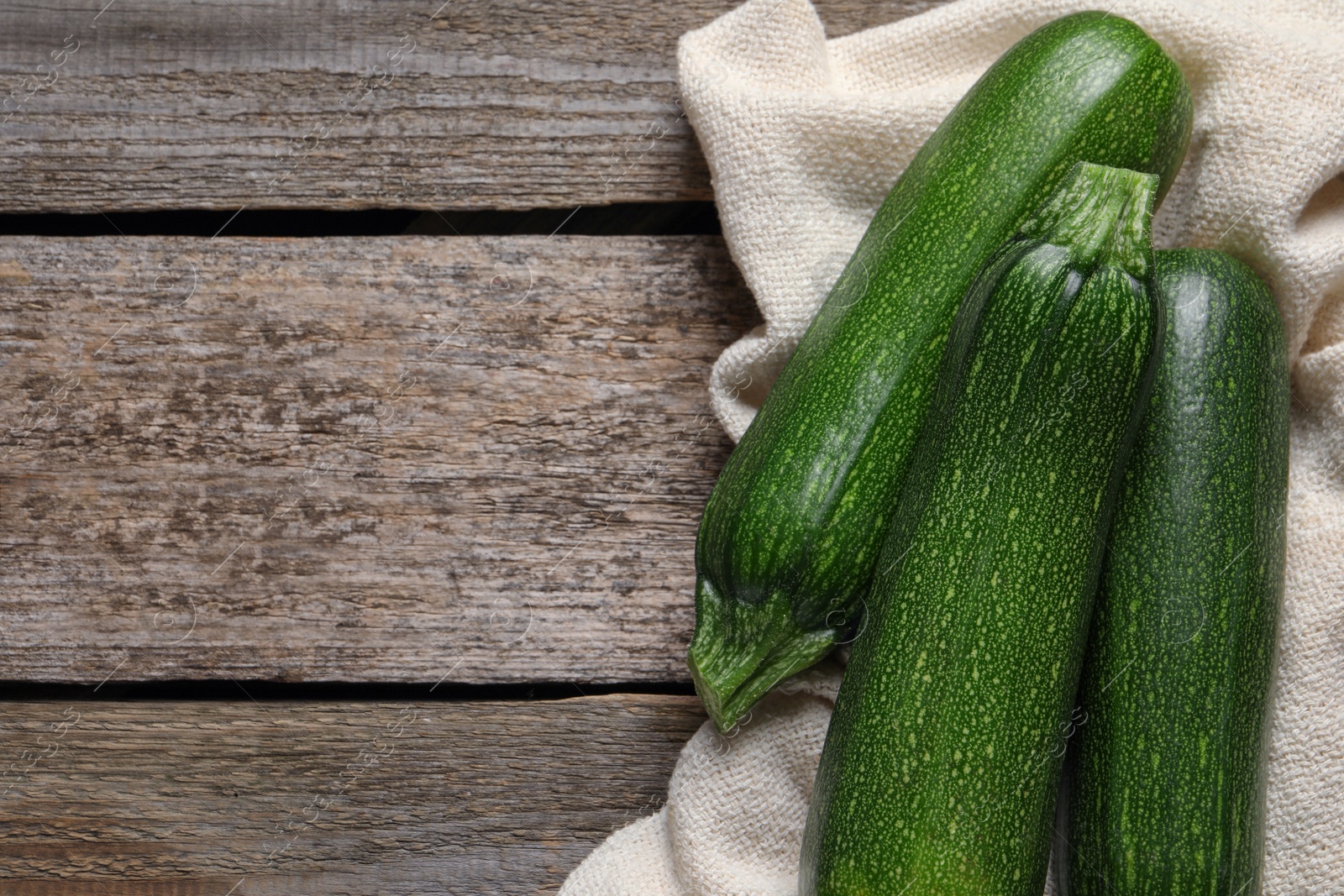 Photo of Raw ripe zucchinis on wooden table, flat lay. Space for text