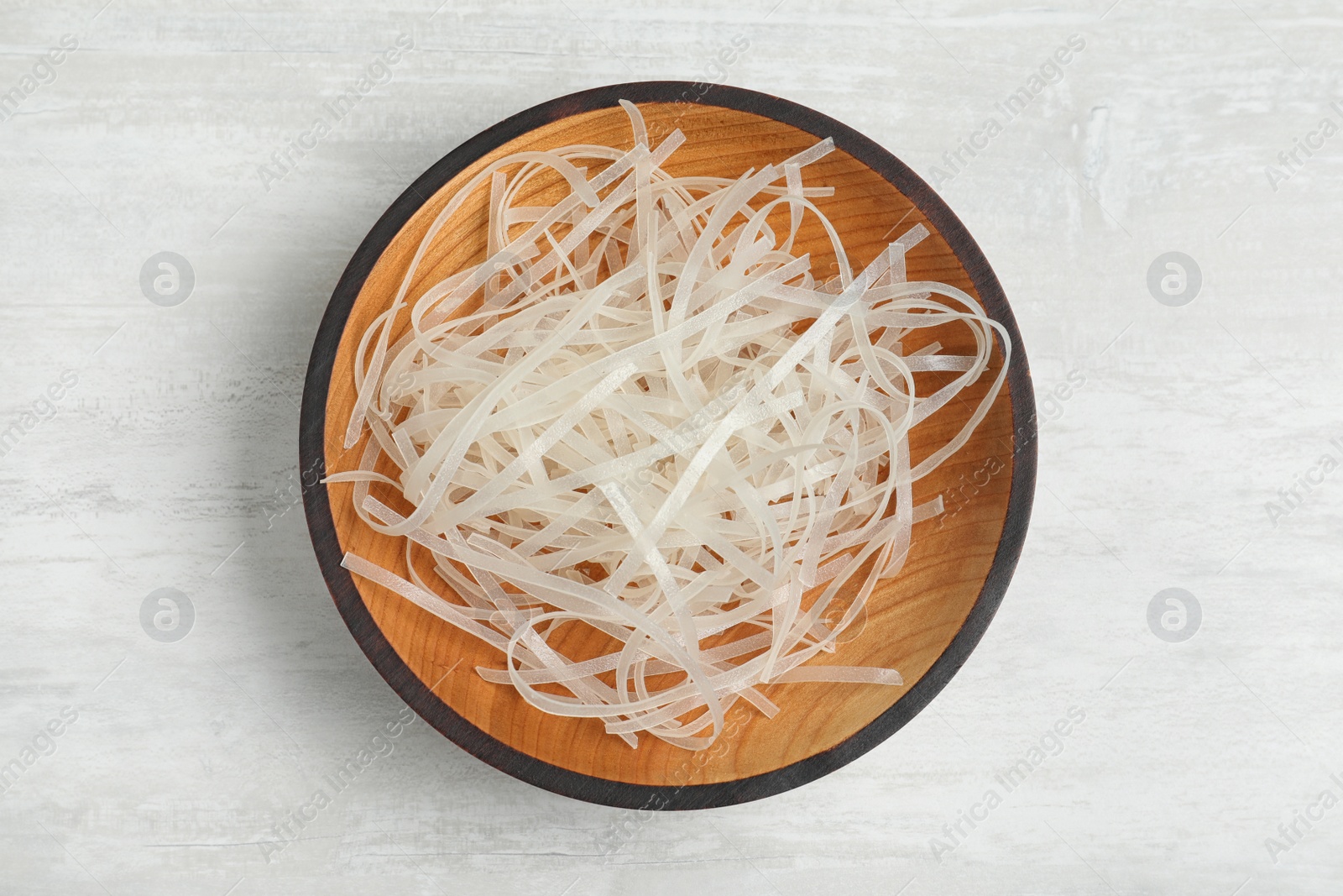 Photo of Plate of uncooked rice noodles on light table, top view