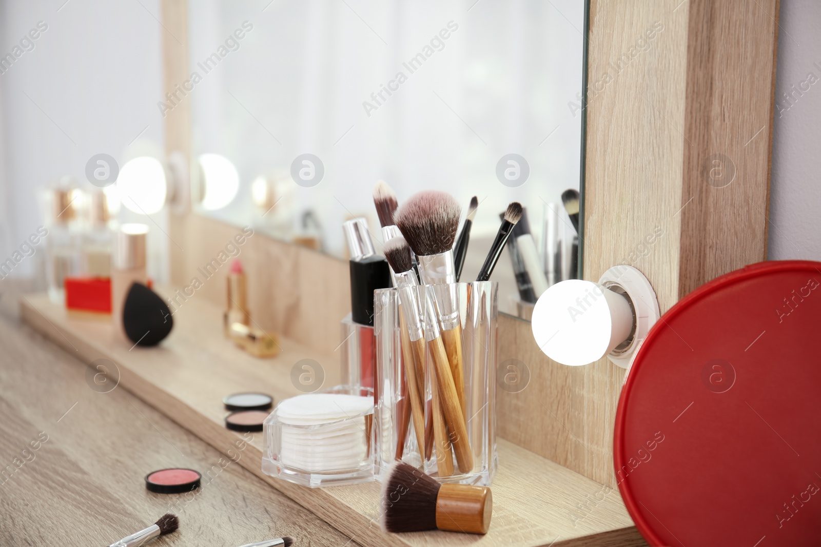 Photo of Makeup cosmetic products and tools on dressing table