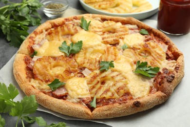 Photo of Delicious pineapple pizza with parsley on table, closeup
