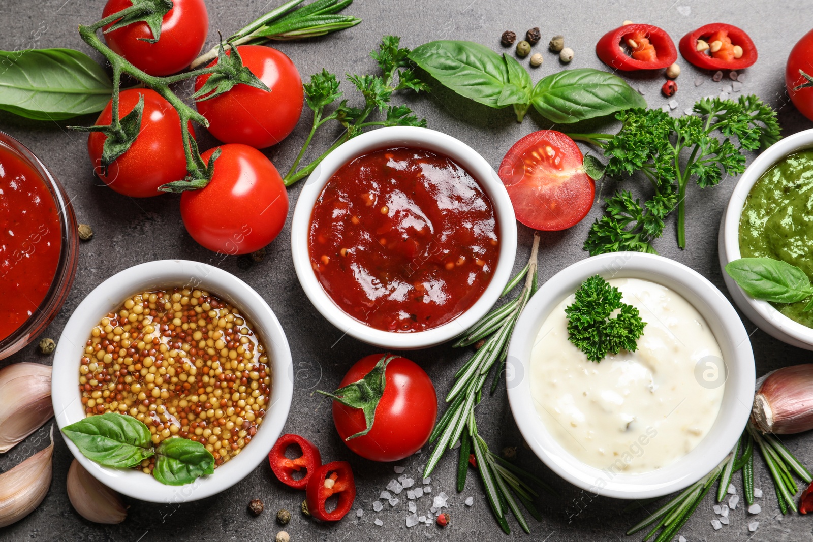 Photo of Flat lay composition with different sauces and ingredients on gray background