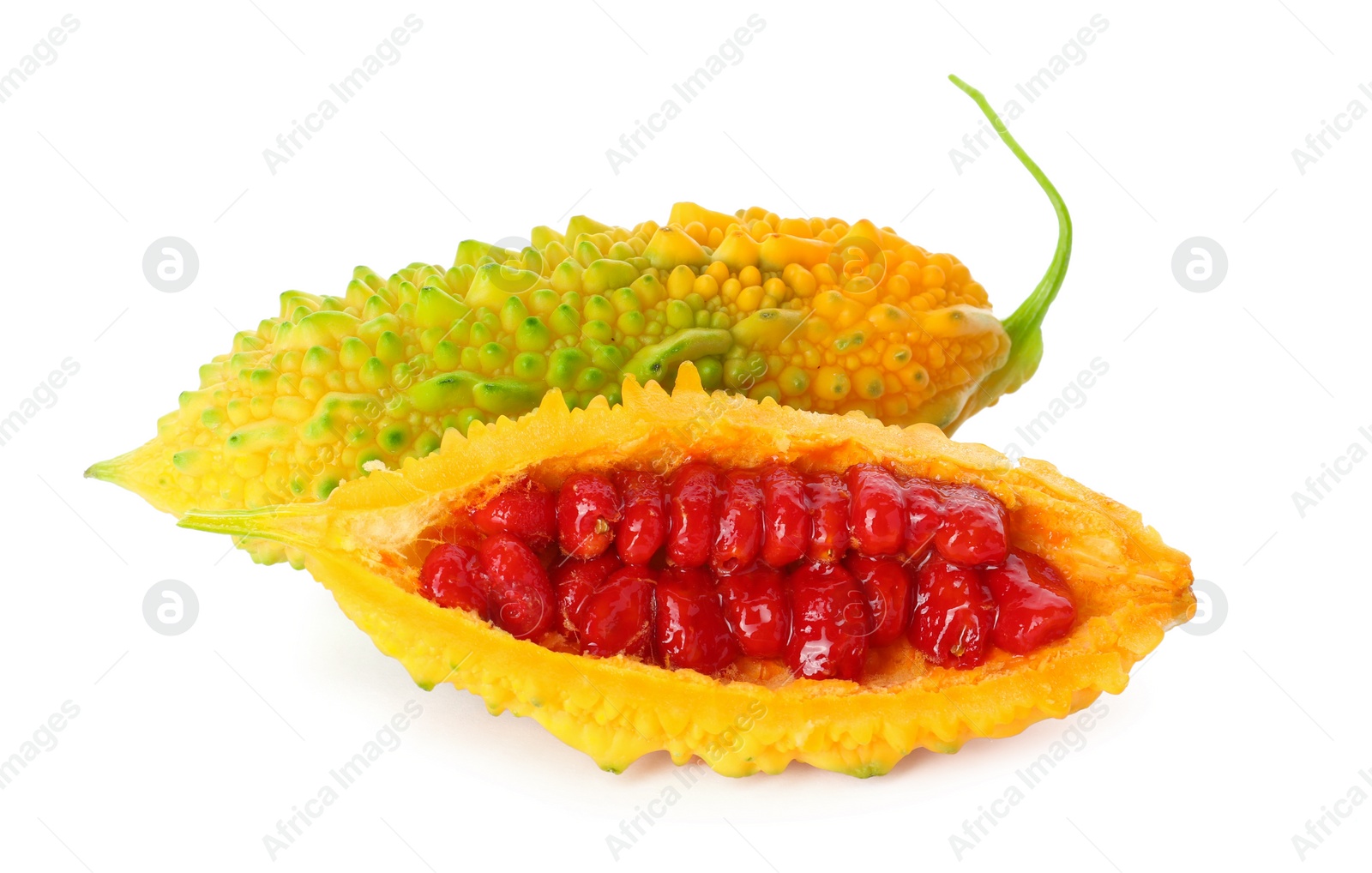 Photo of Whole and cut ripe bitter melons on white background