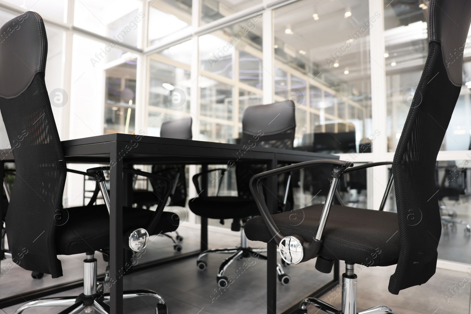 Photo of Comfortable office chairs and tables in meeting room