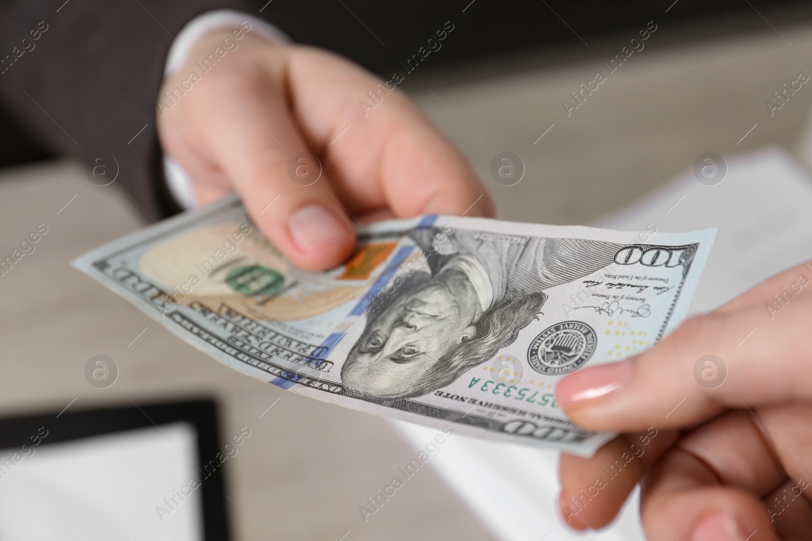 Photo of Man giving money to woman at light table, closeup. Currency exchange