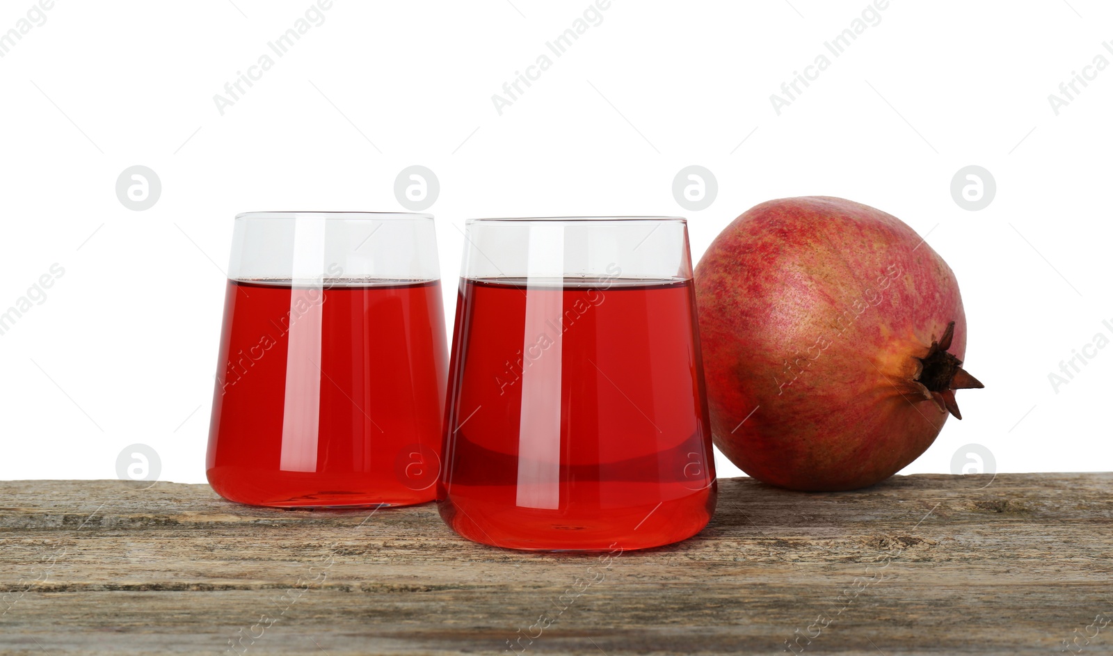 Photo of Refreshing pomegranate juice in glasses and fruit on wooden table against white background