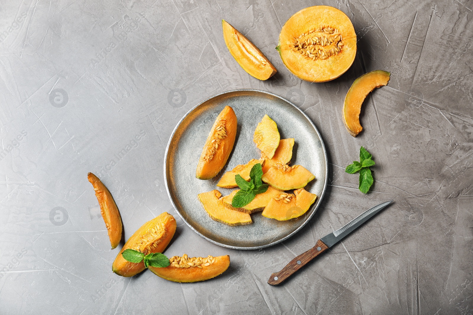 Photo of Slices of ripe melon on light table, flat lay