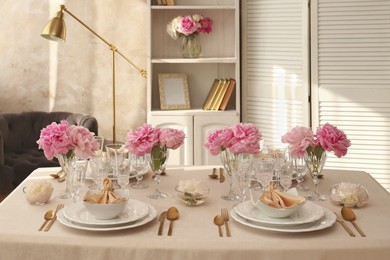 Photo of Stylish table setting with beautiful peonies and fabric napkins indoors