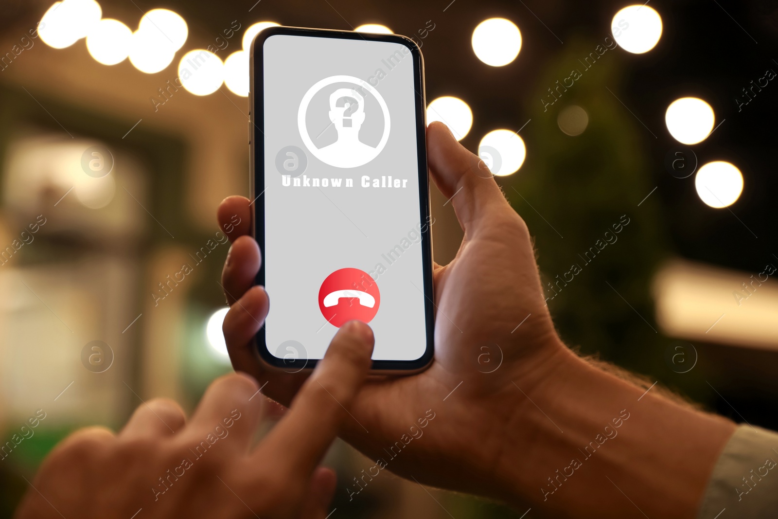 Image of Man declining incoming call from unknown caller outdoors at night, closeup. Be careful - fraud