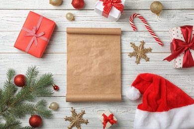 Flat lay composition with empty Santa's list and Christmas decoration on wooden background