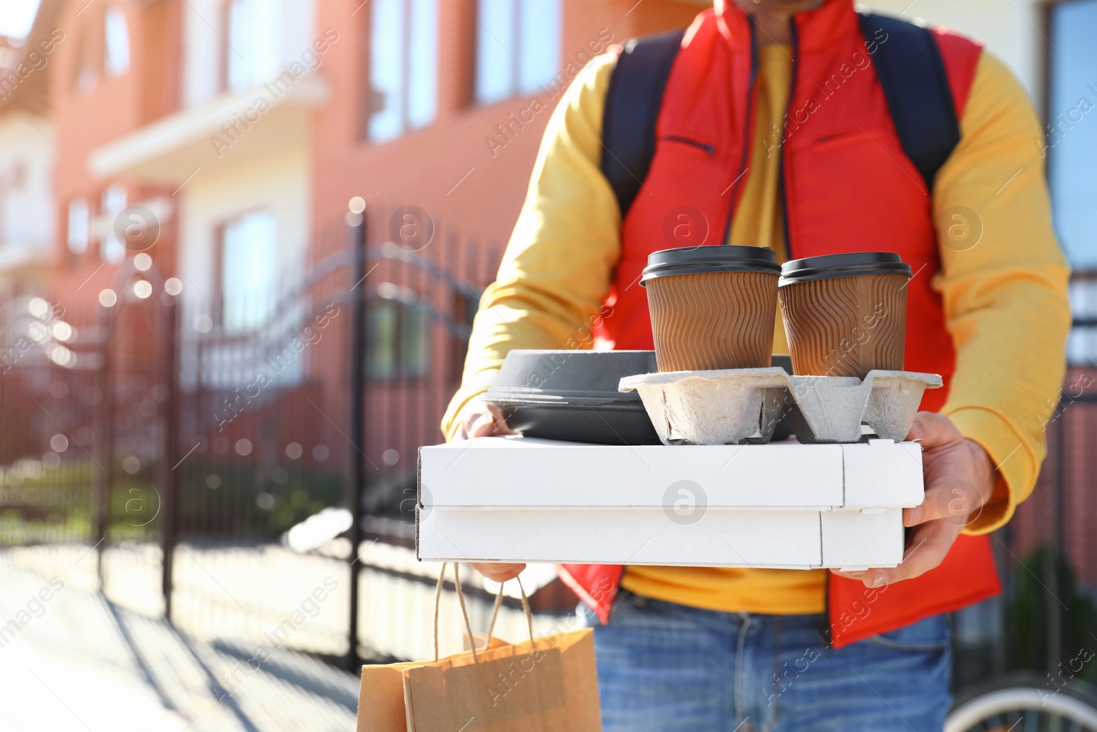 Photo of Male courier delivering food in city on sunny day, closeup