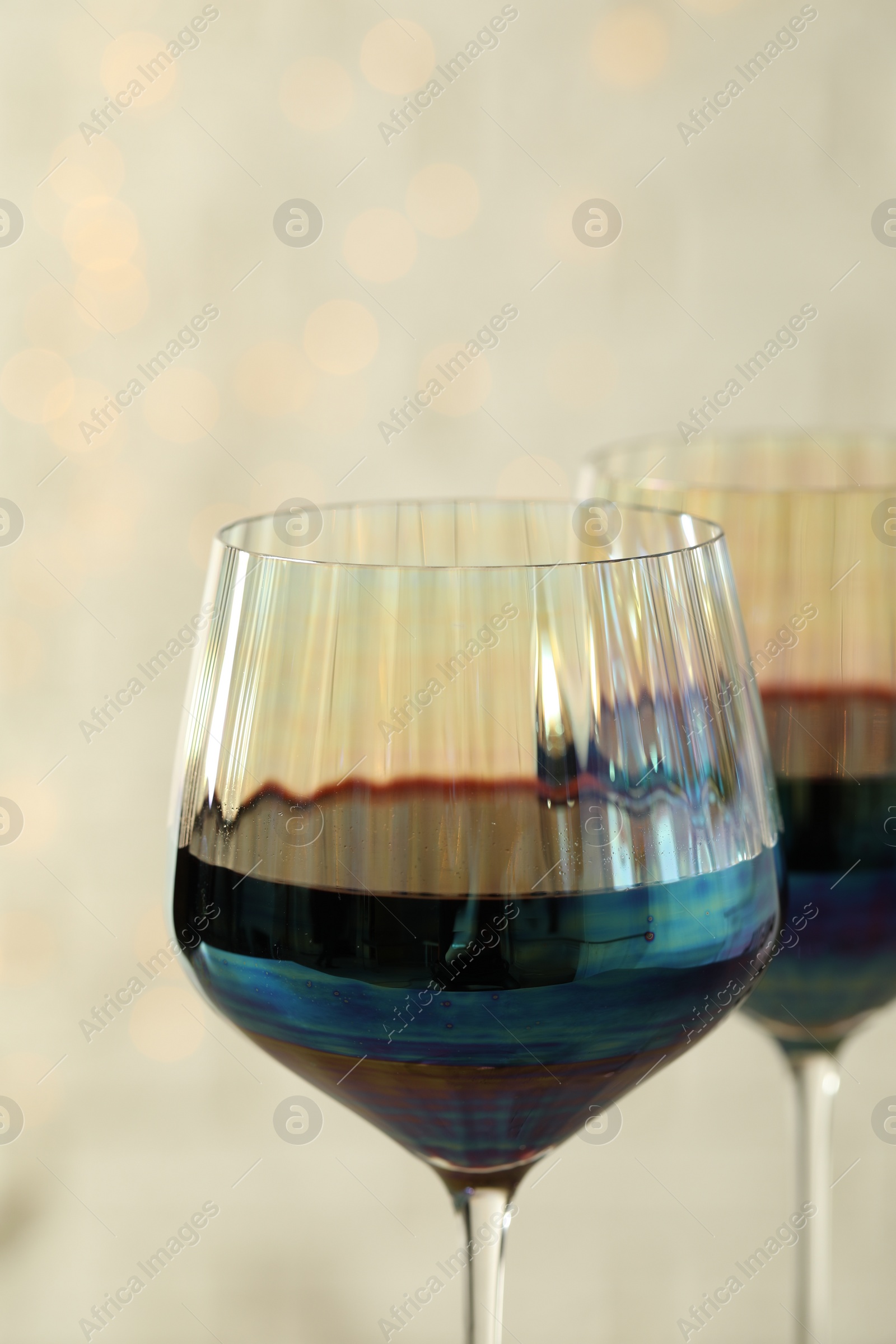 Photo of Glasses of red wine on light background, closeup