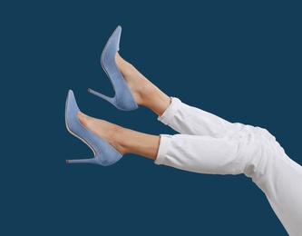 Photo of Woman in elegant shoes on dark blue background