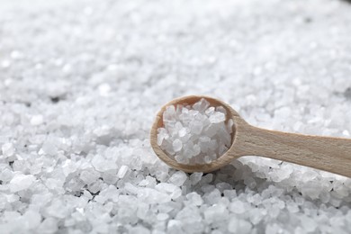 Photo of Natural salt and wooden spoon, closeup view