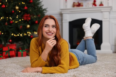 Beautiful young woman in room decorated for Christmas