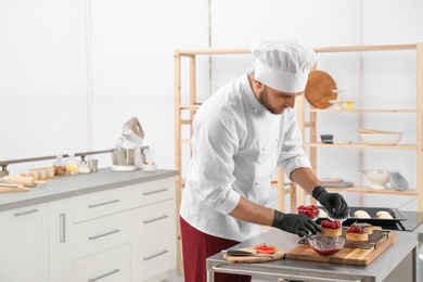 Photo of Male pastry chef preparing desserts at table in kitchen. Space for text