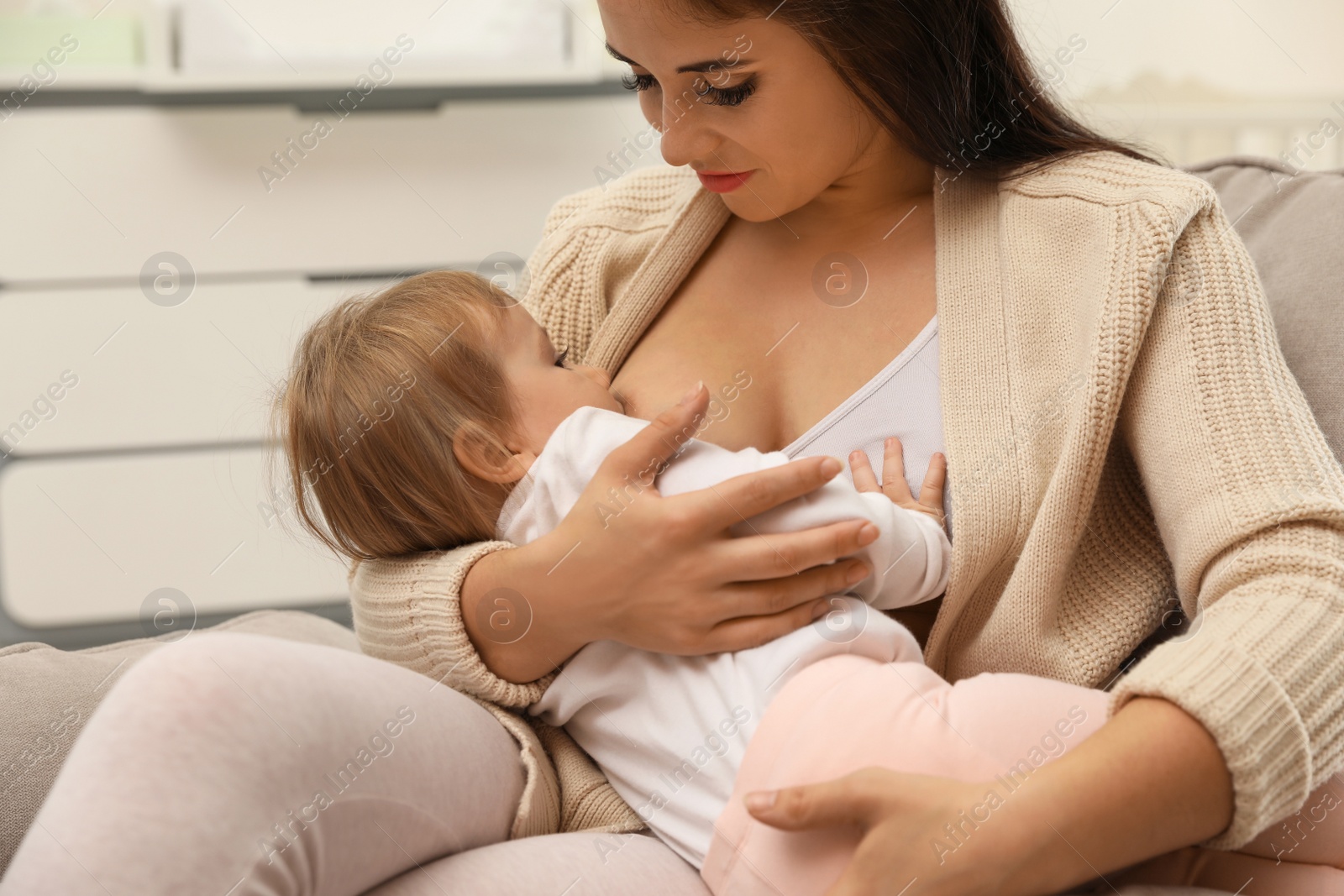 Photo of Woman breastfeeding her little baby at home