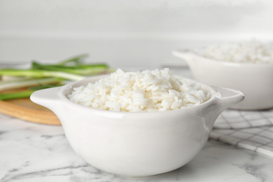 Photo of Bowl with tasty cooked rice on marble table, closeup