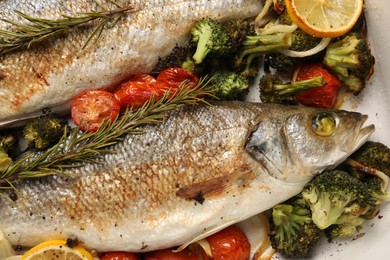 Photo of Delicious fish with vegetables in baking dish, flat lay