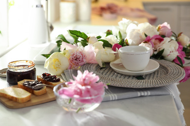 Beautiful peonies and breakfast on kitchen counter