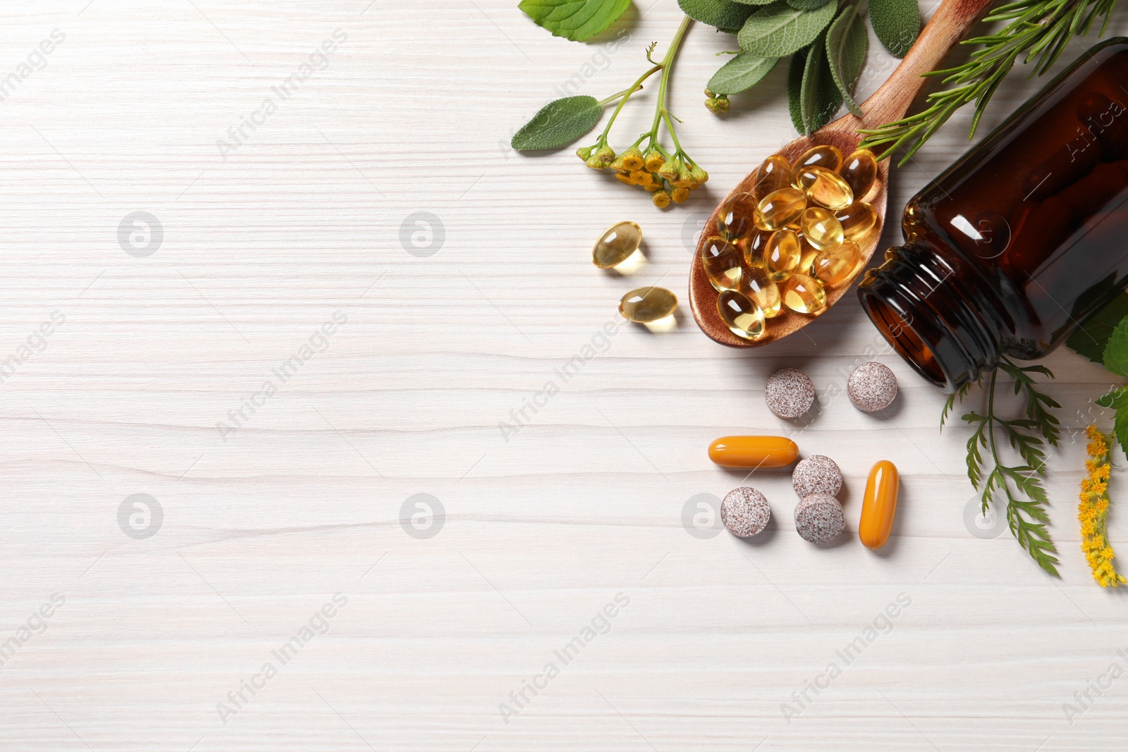 Photo of Different pills, herbs and flowers on white wooden table, flat lay with space for text. Dietary supplements